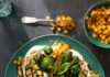 Grilled Zucchini with Tahini Yogurt & Corn Relish a plate of grilled zucchini in a yogurt sauce adn with a corn relish sits on a green plate witha. fork full above it.