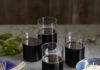 Stanley Tucci Inspired Bucatini all’Amatriciana A Stanley Tucci Inspired Bucatini all' Amatriciana sits in a blue bowl with four glasses of wine placed behind the pasta.