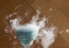 Snow Miser Cocktail A Tiffany Blue colored winter cocktail called Snow Miser, in a Nick and Nora glass with dry ice.l