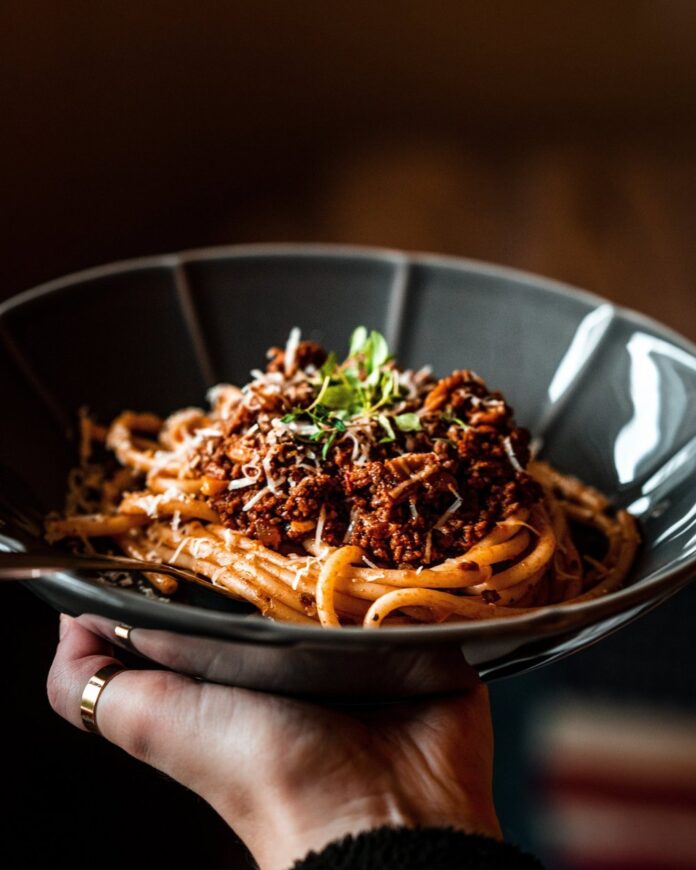 A meaty pasta dish in a black bowl