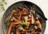 TABLE Magazine’s Ultimate Guide to Passover Tzimmes, a roasted root vegetable dish served in a large grey bowl with a dried fruit sauce.
