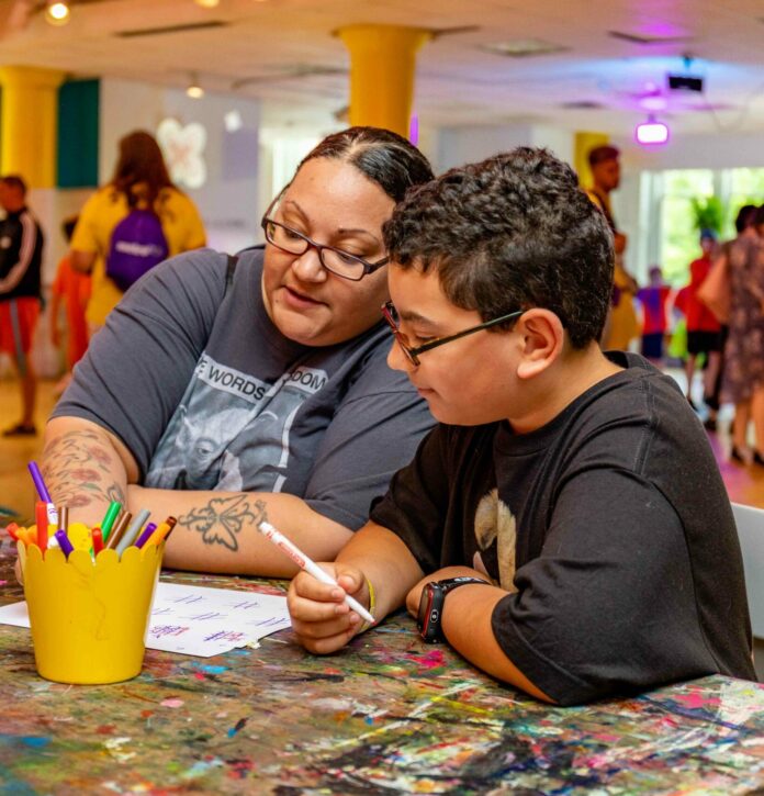 A mother and child sit at a table and color. Rainy day activities for kids