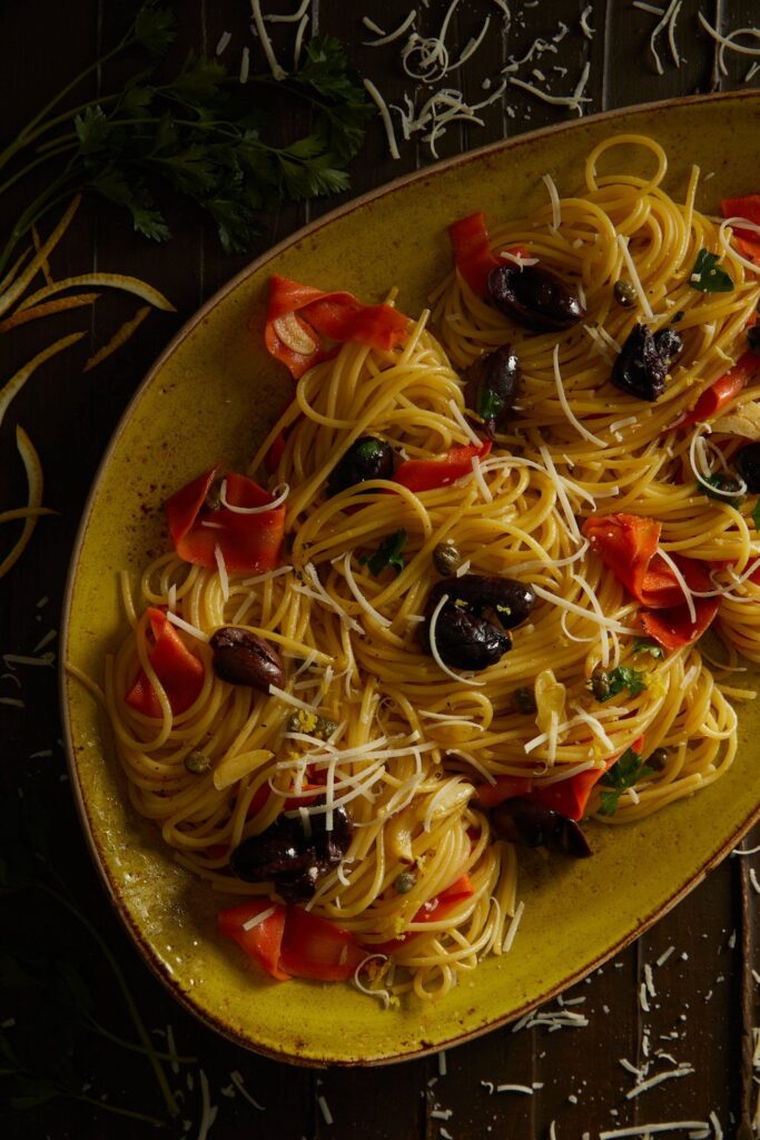 a full plate of Lemon Spaghettini with Olives and Anchovies lying on a table