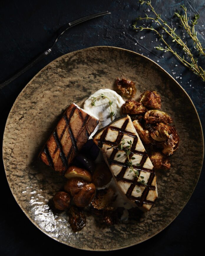 2 pieces of white fish with grilling marks, Brussels sprouts, and mushrooms on a plate. allergen-free