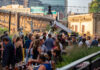 9 Most Fun Annual Pittsburgh Fundraisers An image of a crowd of people mingling at a fundraiser. The city of Pittsburgh is in the background.