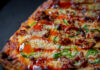 Satisfy Your Pizza Cravings with These 4 Pittsburgh Pizza Joints corner of a square pizza with jalapeño peppers, cheese and sauce