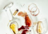 Pittsburgh Experts Recommend 4 Local Restaurants with Exceptional Wine Lists 4 wine varietals in clear wine glasses laying flat on a white surface with spilled wine and circular wine stains