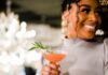 Mother’s Day Reservation Round-Up 2023 an attractive woman holding a cocktail in a restaurant