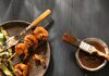 Apple Butter BBQ Sauce Apple Butter BBQ Sauce in a small bowl with a brush placed on it. Shrimp on sticks with bbq sauce on them.
