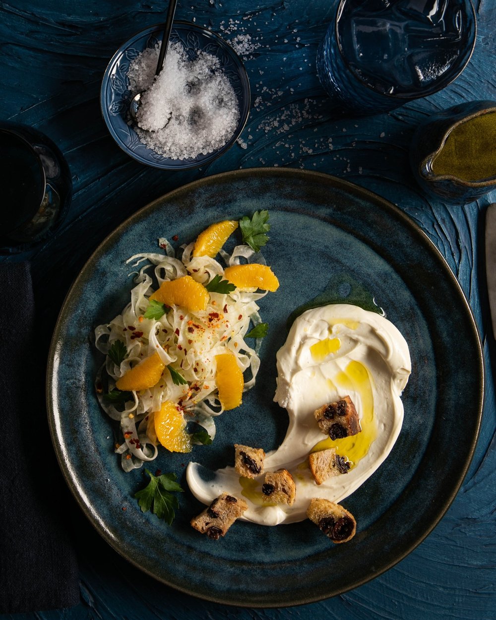 Fennel Orange Salad served on a plate, which is placed on a blue surface