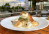 Summer is Here! Rivers Casino Pittsburgh Debuts Dining Alfresco a dish of pasta with lobster and shrimp on a white plate set on a wooden table outside
