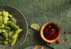 Thai Pork Meatball Skewers A flat-lay image of Thai Pork Meatball Skewers with limes for garnish and topping.