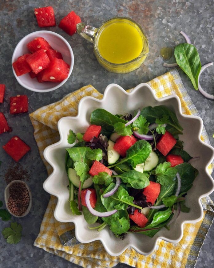 Watermelon salad in a spiral bowl, which is placed on a napkin, Pieces of watermelon in a smaller bowl