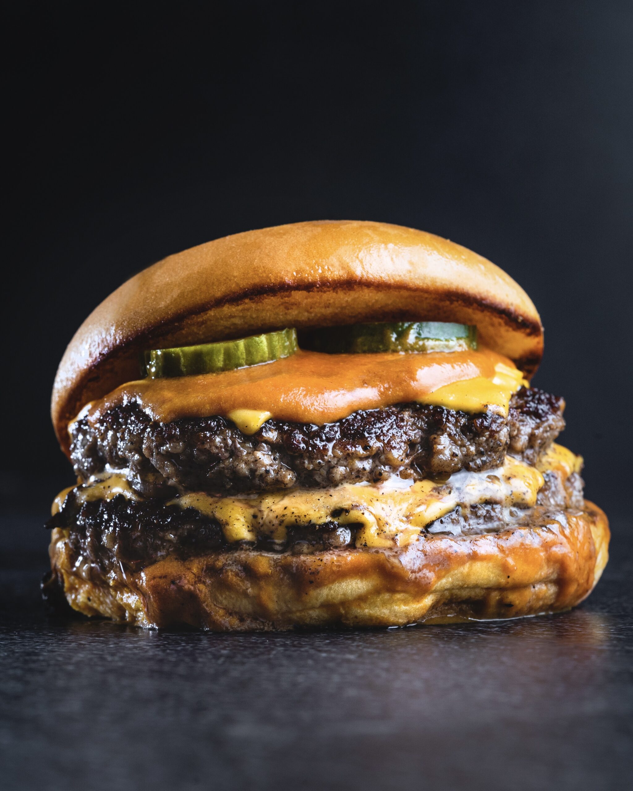 a look in photo of a double cheeseburger with pickles