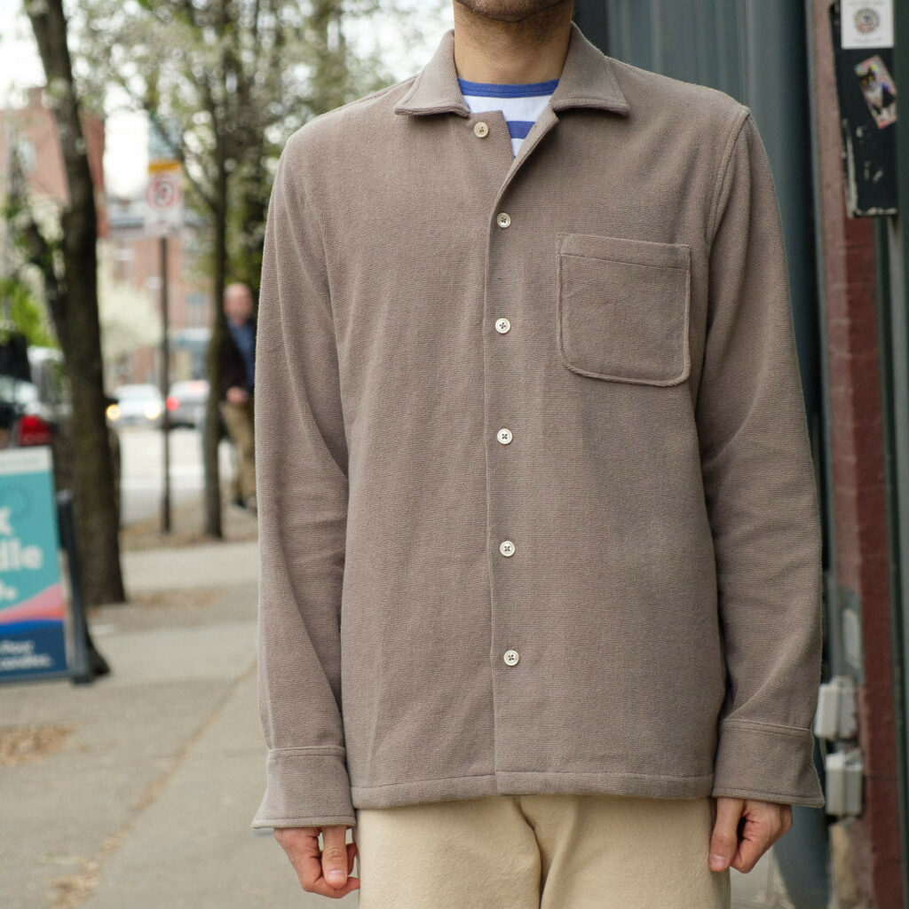 the torso of a male wearing a light brown terry overshirt.
