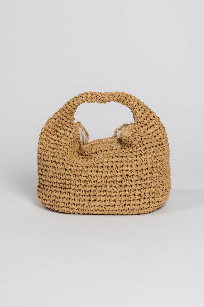 A semi-floppy straw tote against a white background.