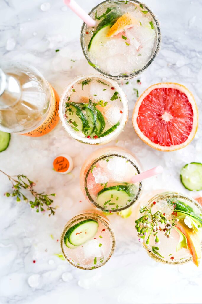 An aerial shot of moscow mules garnished with grapefruit and cucumber, bright in color.