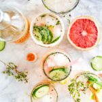 An aerial shot of moscow mules garnished with grapefruit and cucumber, bright in color.