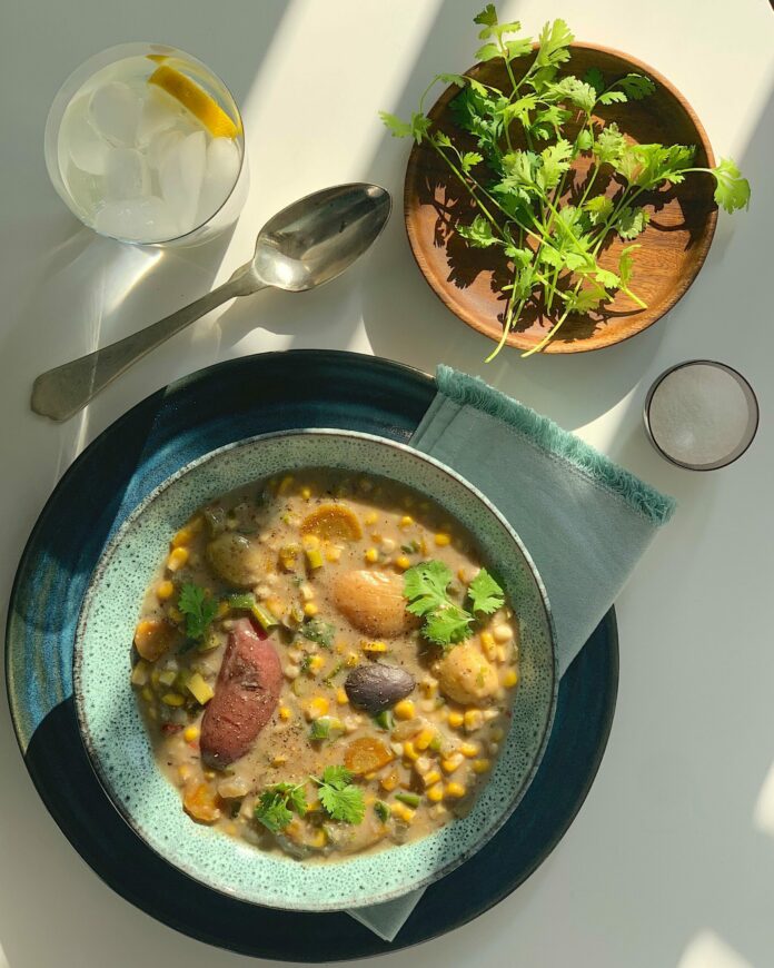An aerial view of corn chower in a light blue-green bowl. corn chowder recipe