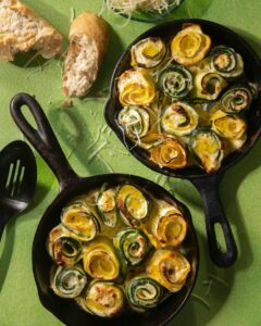 Zucchini and yellow summer squash fill two cast iron pans.