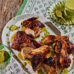An aerial shot of crispy Roast Chicken with Spicy Green Sauce sitting on a white serving tray.
