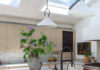 Pittsburgh’s Allegheny Millwork Turns an Old Sunroom into a New Kitchen A kitchen island with white marble top and a vase with purple flowers on it too.