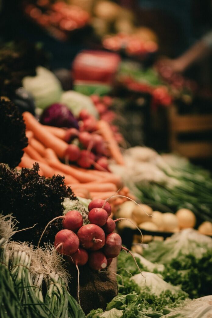 an assortment of fresh fruits and veggies at a farmers market.