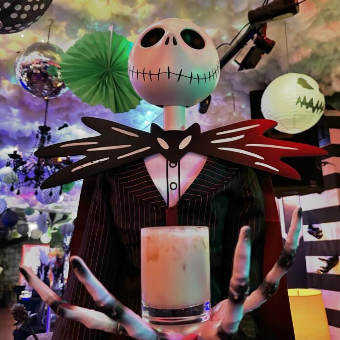 Pittsburgh Halloween Bars to Eat, Drink, and Be Spooky A Jack Skellington doll holds a cocktail in his hand at a Halloween bar.