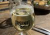 5 Taprooms in Pittsburgh for Cider Cravings A glass of cider in an Arsenal Cider House cup on a wooden table.