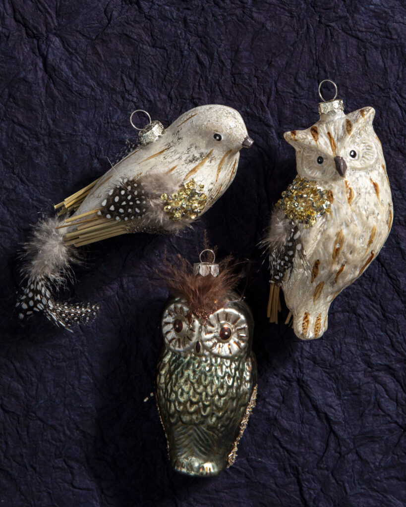 Three bird ornaments including two owls and a dove.