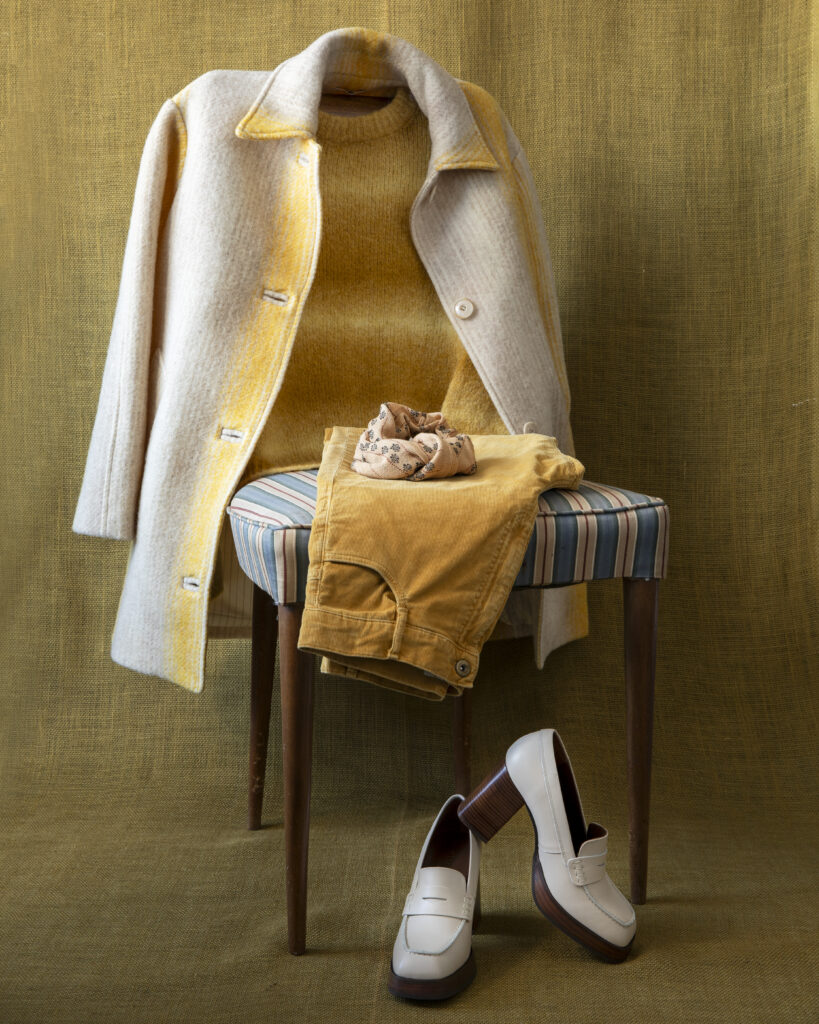 A polo coat styled with pants and shoes on a chair.