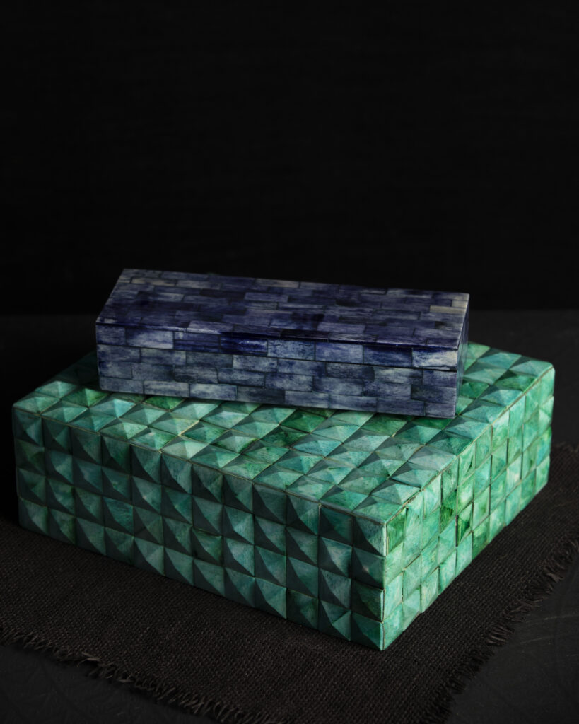 Two colorfully dyed boxes on a black backdrop, one green and one marble blue.