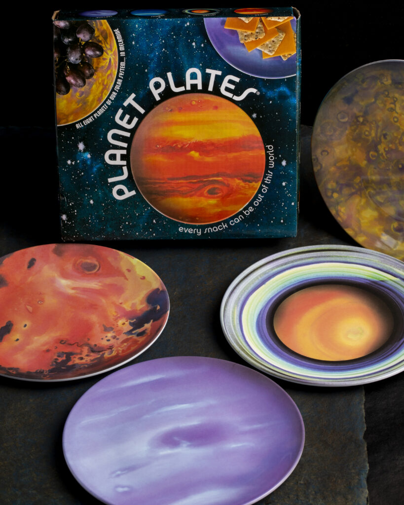 Plates colored like various planets sit on a table in front of the item box displaying the words "Planet Plates."