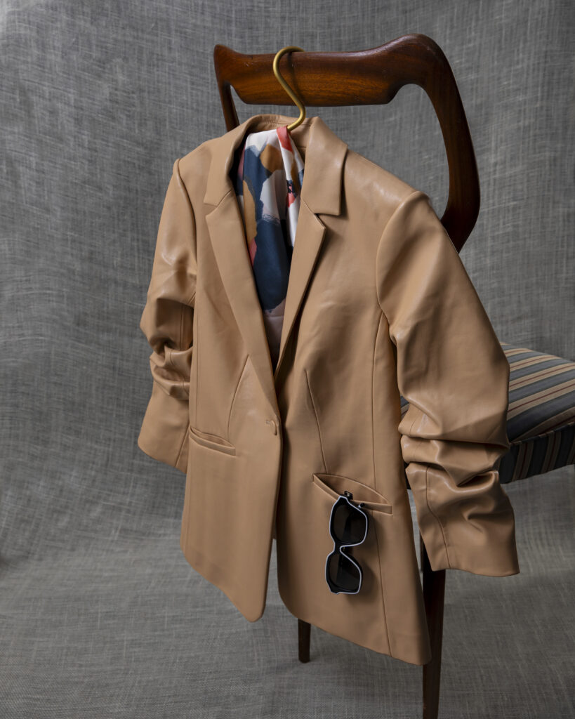 A cool brown blazer styled on a brown chair.