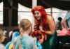 Pittsburgh Happenings: November 14-20 A woman dressed as Ariel from The LIttle Mermaid holds a crab stuffed animal and speaks to little girls in dresses.