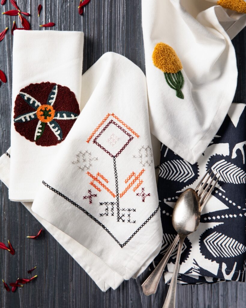 A three set of kitchen towels for the home with embroidered designs.