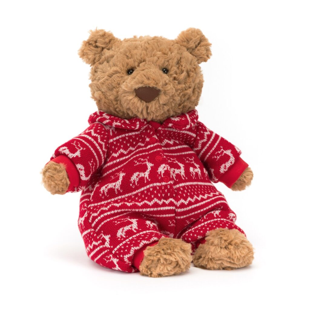 A small brown teddy bear with a red reindeer sweater sits on a white background.