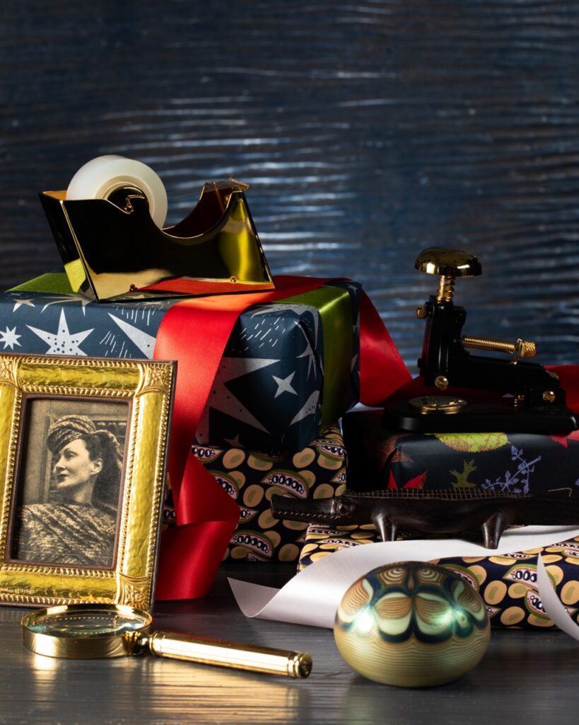 An American flag box sits underneath a tape roller and behind a framed vintage photo of a woman.