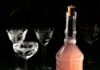 Try Making an Edible Gift This Holiday Season A bottle of Sugar Plum and Sage Infused Vodka sits on a table in front of three tall glasses.