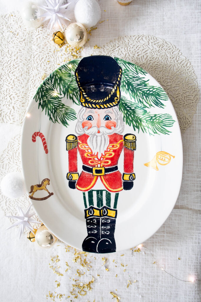 A nutcracker painted on a serving tray on a table.