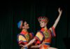 Pittsburgh Happenings: December 2023 Two dancers dressed in colorful red, yellow, and blue outfits striking a pose on stage.