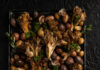 50 Thanksgiving Side Recipes to Fill Your Dinner Table with Gratitude Roasted Wild Mushrooms and Potatoes with Chimichurri served in a black tray with a black background
