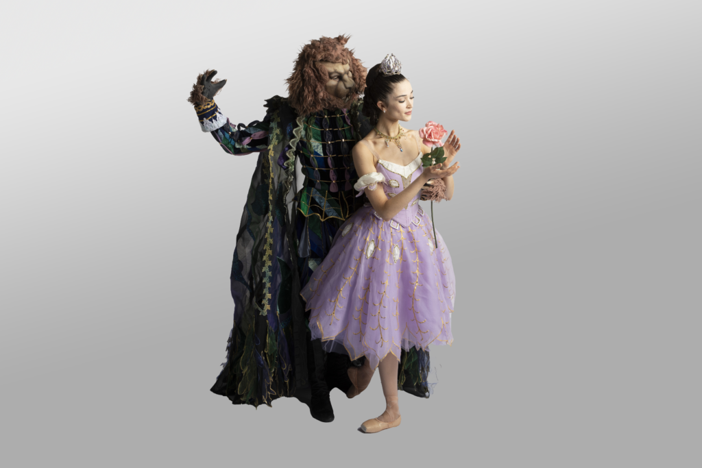 A man dressed in a beast costume holds onto a ballerina in a purple dress and crown.