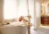 5 Things To Do on Spring Break in Pittsburgh A woman with a towel on her head lays in a bathtub with a tray nearby in a luxurious white hotel room.