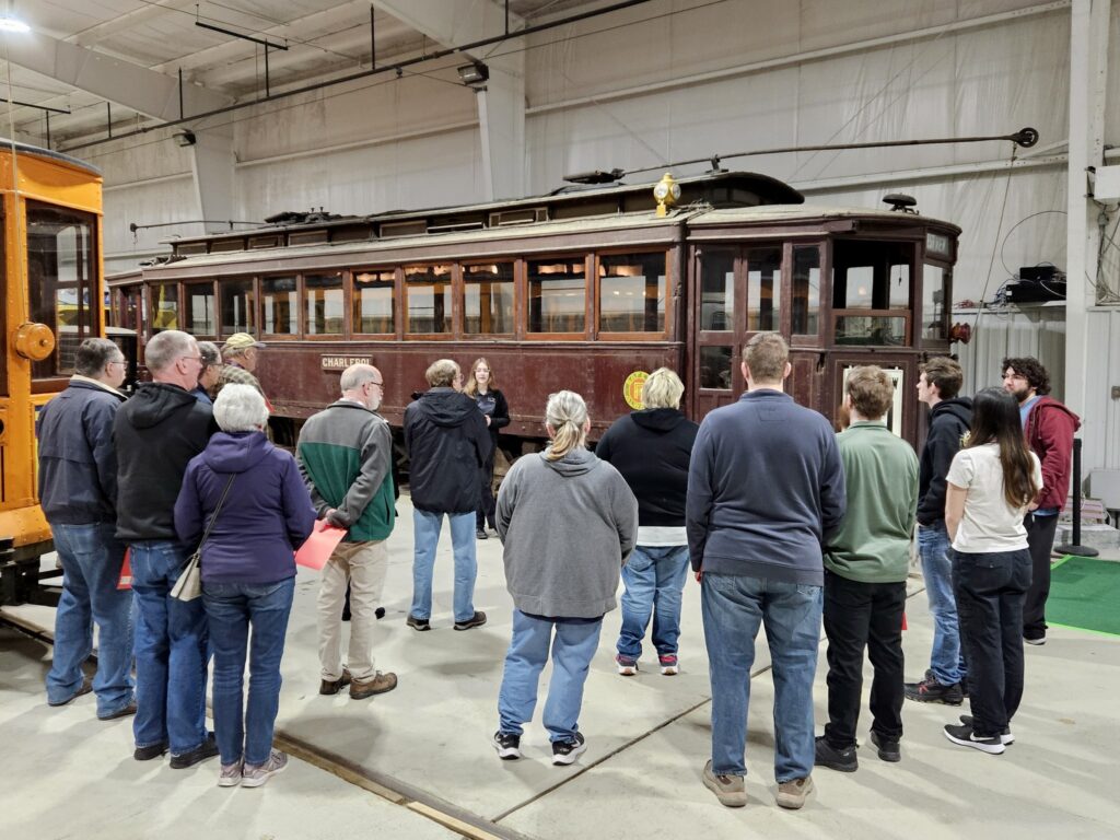 A group of visitors looks at an old, rundown trolley in the Pennsylvania Trolley Museum.