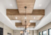 Armina Stone Elevates Pittsburgh’s Homes with Curated Natural Stone from Around the World Photo of a long kitchen with a grey marbled waterfall island in the center, windows on the right, and cream colored cabinets.