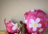 Easter Candy, Chocolate, and Goodies in Pittsburgh In front of a big, broken pink Easter egg sits various chocolate bunnies, eggs, macarons, ricotta pie, and confetti.