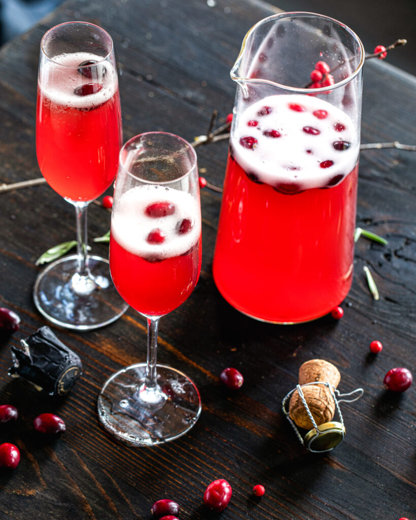 Sparkling cranberry mimosa in a champagne flute, crafted with homemade cranberry juice for a vibrant, festive sip.
