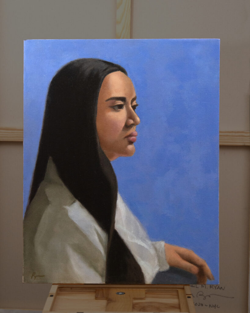 A painting by Oil Painter Rachael Ryan depicts a young woman with long brown hair sitting against a blue background