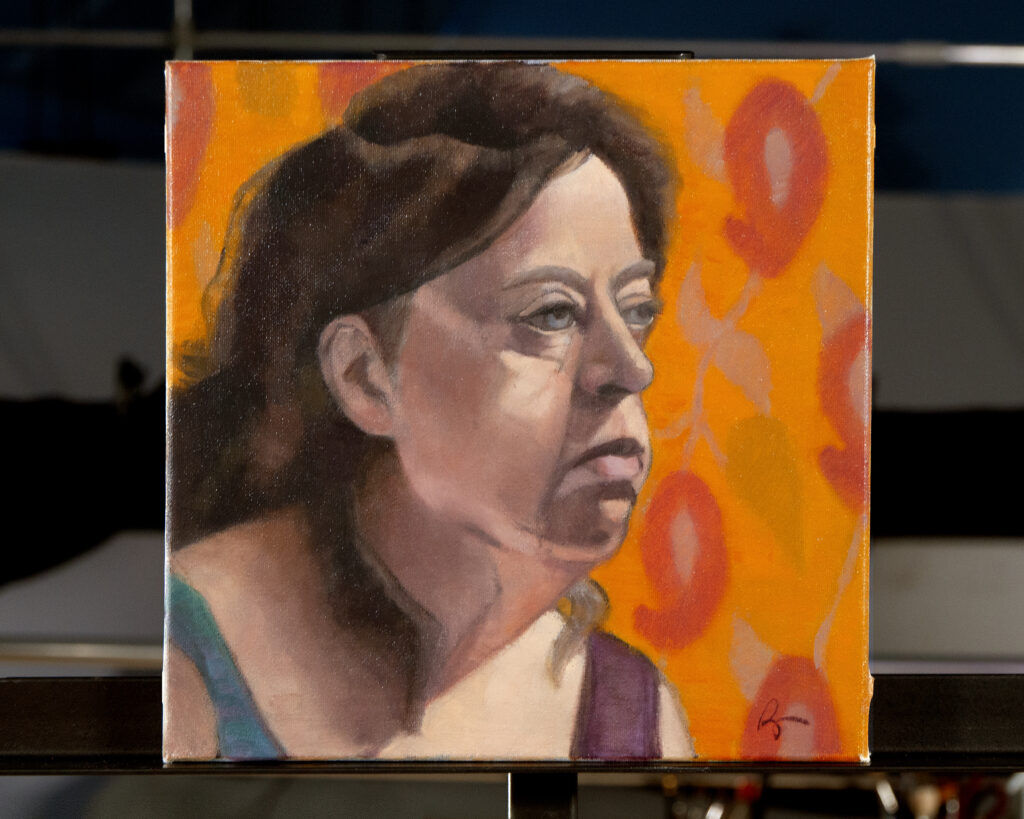 A painting by Oil Painter Rachael Ryan depicts an older woman with brown hair against an orange pattern background.